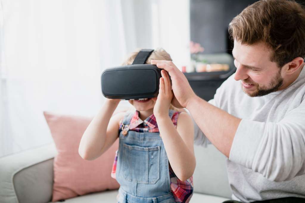 wearable AI device Father putting VR glasses on daughter